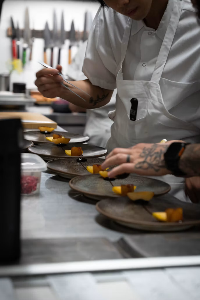 Chef finishing plated dishes